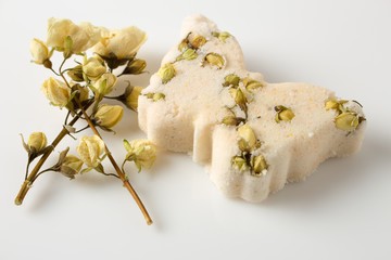 Bath bombs decorated with dried linden flowers on a white