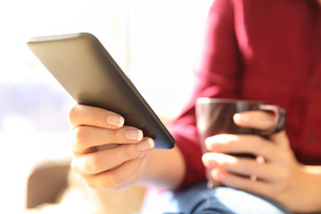 Woman hands using a smart phone and holding drink