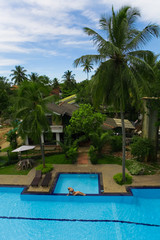 Slender girl in a bikini sunbathing around the pool.