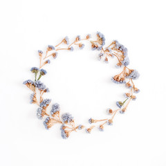 Frame wreath of pale blue dried flowers on white background. Flat lay, top view