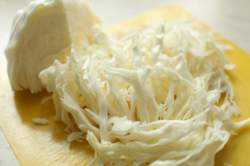 Sliced white cabbage on a yellow cutting board