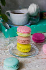 Different macaroons on a light wooden background and bird-cherry branches
