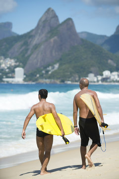 Bright view of Ipanema Beach in Rio de Janeiro, Brazil with surfers passing in front of Two Brothers Mountain