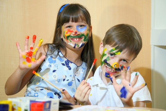 Joyful children with paints on their faces.