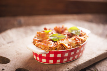 Lasagna bolognese in a baking dish on a rustic table