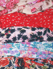 Pieces of colorful patterned floral fabric or clothing. Summer and spring fashion. Flat lay. Top view.