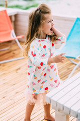 Little cute girl with seashell in hands at tropical beach