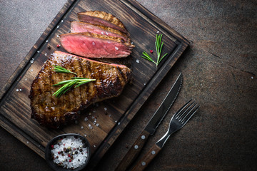 Steak de boeuf grillé sur planche de bois. Espace de copie vue de dessus.