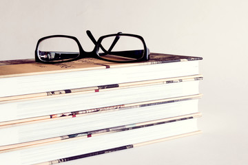 Reading glasses on a pile of books
