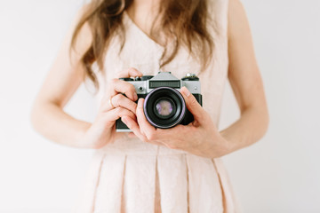 Happy young woman holding in hands old vintage camera. Girl photographer