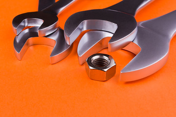 Spanners of various sizes, on orange background