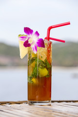 Refreshing drink with lime, mint and pineapple on a tropical beach