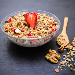 Diet breakfast. Oatmeal porridge with blueberries, strawberries, muesli and a spoon on wooden background. Top view.