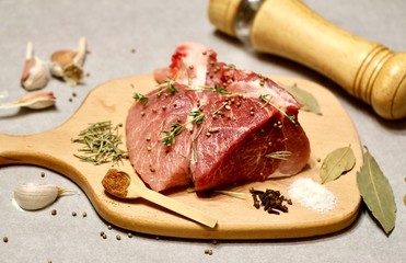 raw meat on a wooden cutting board with spices
