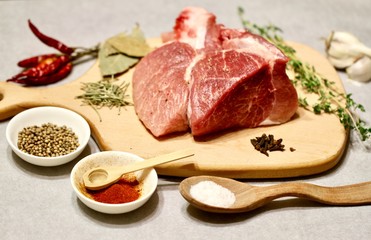 raw meat on a wooden cutting board with spices