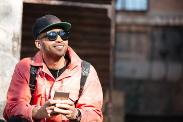 Young stylish afro american man in cap and leather jacket