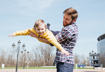 Father and his little son playing together in a park