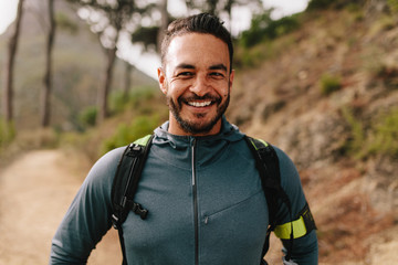 Smiling young male runner on country road