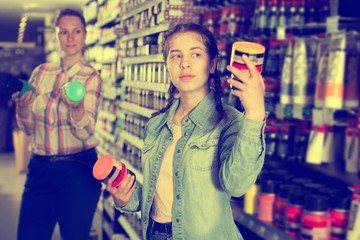 Mother and daughter holding jar with color paint