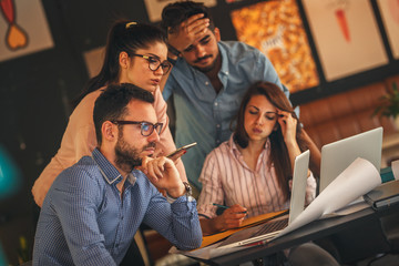 Group of casual business people working on new project .They using laptop and discuss about concept.Solving problems.