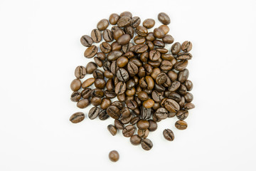 Still life with close-up view of grains of roasted brown coffee isolated on a white background