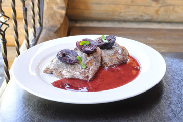 Fried meat with plum sauce on a white plate