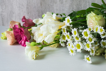 A bouquet of white freesia, lisianthus, chrysanthemum and roses.