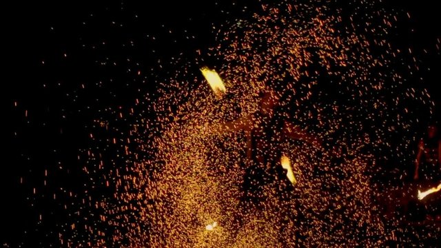 An amazing fire show at night. A man spinning fire. Long shot