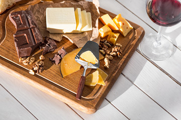 The different kind of cheese and walnuts on wooden background