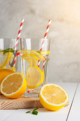 Fresh citrus lemonade in the glasses,concrete grey background, sunlight