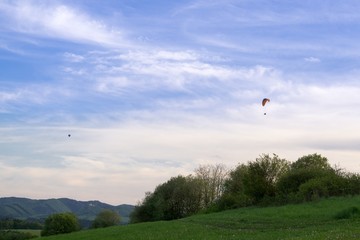 Paraglider and balloon flying in the air during colorful sunset. Slovakia