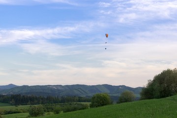 Paraglider and balloon flying in the air during colorful sunset. Slovakia