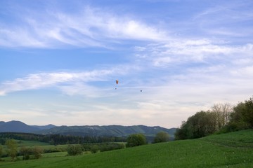 Paraglider and balloon flying in the air during colorful sunset. Slovakia