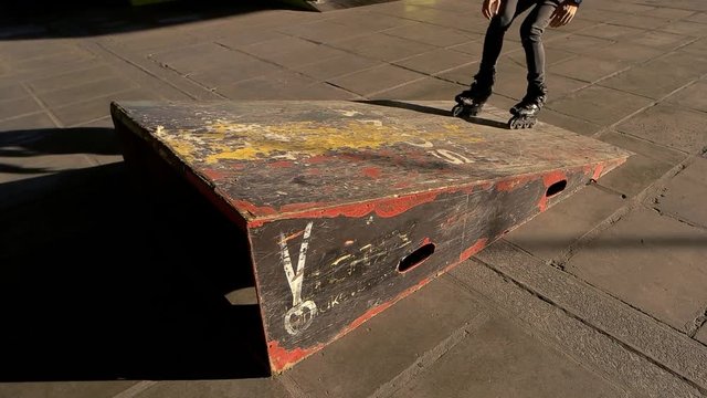 Legs of rollerblader and ramp. Person on inline skates jumping. Straight into the air.
