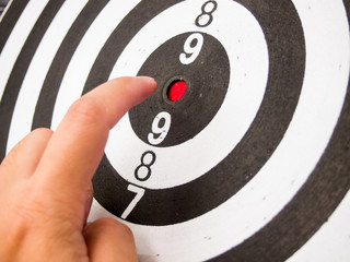 Black and white dart with hand point at center (Concept for target, achievement, business focus)