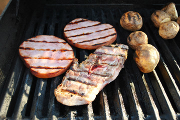 Grilling a Lamb Chop, Ham Steaks, and Whole Potatoes 