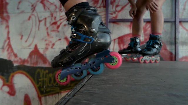 Feet of rollerblader, slow motion. Inline skates with colorful wheels. Best sports equipment.