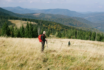 Fototapeta na wymiar Hiker with backpack admire green Carpathian mountains