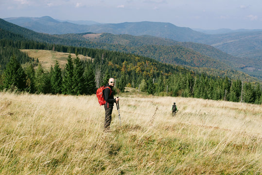 Hiker with backpack admire green Carpathian mountains