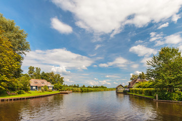 Fototapeta na wymiar River with old houses in Dutch national park Weerribben