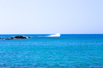 Rocky shore of the Mediterranean Sea. On the horizon, a natural stone breakwater. Toned