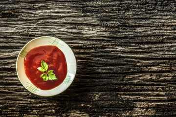 tomato sauce and tomatoes on wooden background