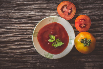 tomato sauce and tomatoes on wooden background