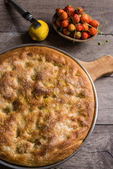 focaccia dolce al limone, cocco e fragole su base di legno rustica; vista dall'alto