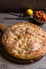 focaccia dolce al limone e cocco con crosta di zucchero fatta in casa appoggiata su tagliere di legno
