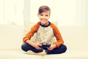 happy boy with joystick playing video game at home