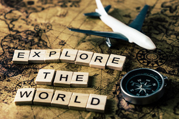 Explore the world concept on vintage map with compass and airplane