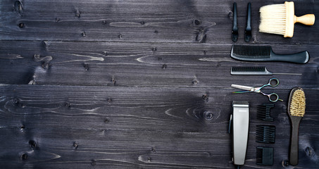 Hairdresser tools on wooden background. Top view on wooden table with scissors, comb, hairbrushes and hairclips, free space. Barbershop