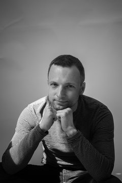 Vertical black and white portrait of sitting man