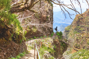 trekking on Madeira island. A route between two peaks Pico Ruivo and Pico do Areeiro. Amazing cliff view with tourist on the edge